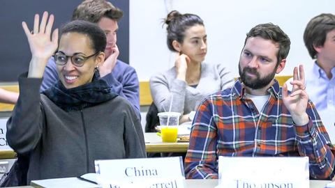 Students raising their hands in class
