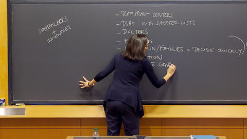 Professor Battilana writing on a chalkboard