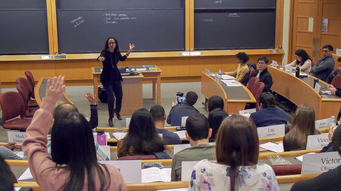 Professor Battilana pointing to students with their hands raised.