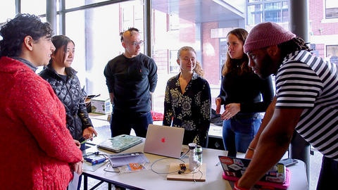 Group of students standing over project fair creation--aluminum can with wires