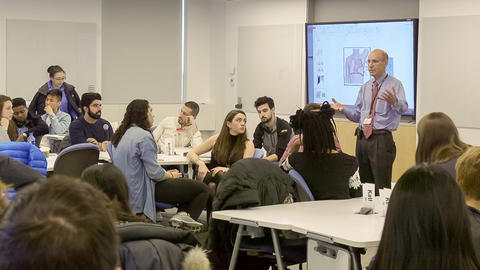 Wide shot of Dr. Schwartzstein instructing in front of a class of seated students.